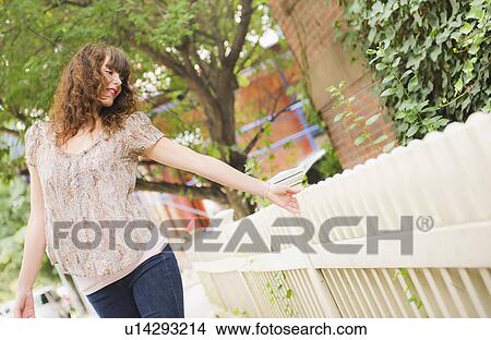 Picture - Woman touching fence. Fotosearch