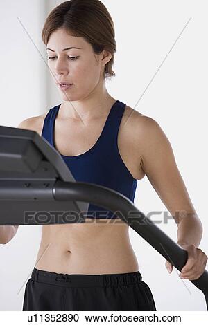 Stock Image - Woman training on treadmill. Fotosearch