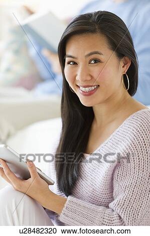 Woman using digital tablet at home View Large Photo Image Stock Image - Woman using digital tablet at home. Fotosearch