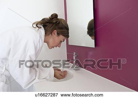 Stock Photo - Woman washing hands in bathroom. Fotosearch