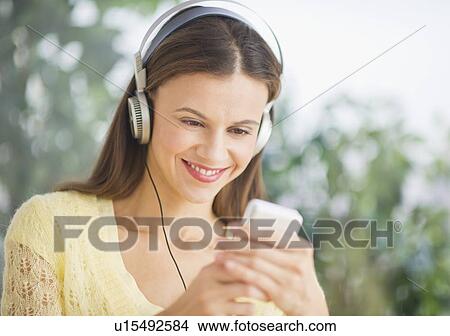 Woman with headphones outdoors View Large Photo Image Picture - Woman with headphones outdoors. Fotosearch