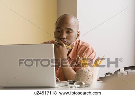 Young businessman working in office View Large Photo Image Stock Photo - Young businessman working in office. Fotosearch