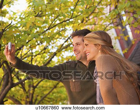 Stock Image - Young couple walking on pavement. Fotosearch