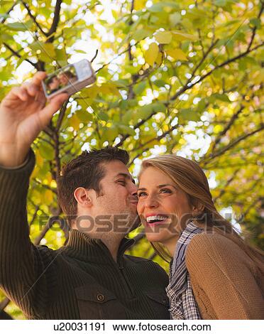 Stock Image - Young couple walking on pavement. Fotosearch