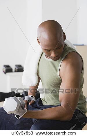 Young man lifting weights in gym View Large Photo Image Stock Image - Young man lifting weights in gym. Fotosearch