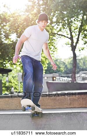 Stock Image - Young man skateboarding. Fotosearch
