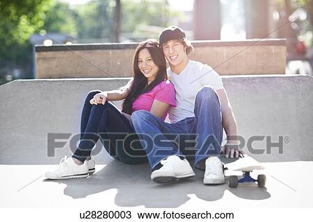 Young multi-racial couple posing with skateboard View Large Photo Image Stock Image - Young multi-racial couple posing with skateboard. Fotosearch