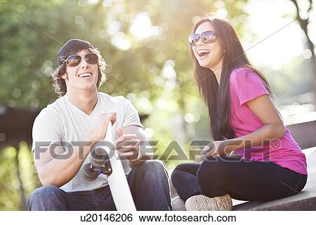 Young multi-racial couple posing with skateboard View Large Photo Image Stock Photograph - Young multi-racial couple posing with skateboard. Fotosearch