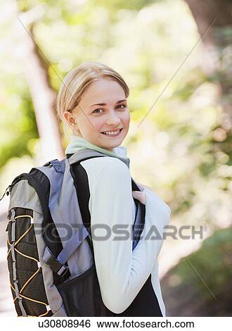 Stock Photograph - Young woman hiking with backpack. Fotosearch