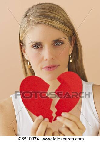 Young woman holding broken paper heart View Large Photo Image Picture - Young woman holding broken paper heart. Fotosearch