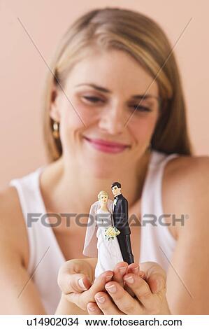 Picture - Young woman holding wedding figurine. Fotosearch