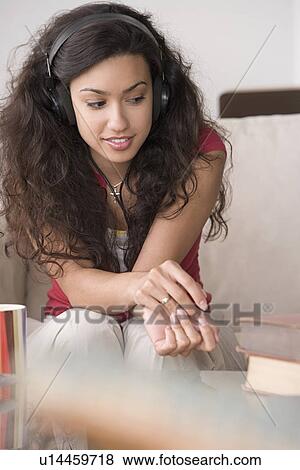 Young woman listening to music View Large Photo Image Stock Photo - Young woman listening to music. Fotosearch