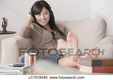 Young woman relaxing at sofa View Large Photo Image Stock Image - Young woman relaxing at sofa. Fotosearch