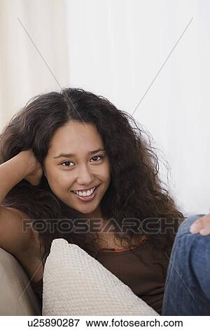Young woman relaxing on sofa View Large Photo Image Stock Photo - Young woman relaxing on sofa. Fotosearch