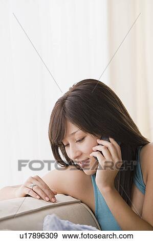 Stock Photo - Young woman talking on mobile phone. Fotosearch