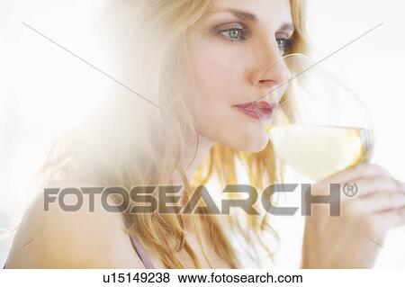 Stock Photo - Young woman tasting wine, studio shot. Fotosearch