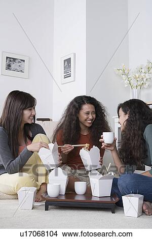 Young women eating take out food at home View Large Photo Image Picture - Young women eating take out food at home. Fotosearch