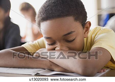 Bored schoolboy sleeping on desk View Large Photo Image Stock Image - Bored schoolboy sleeping on desk. Fotosearch