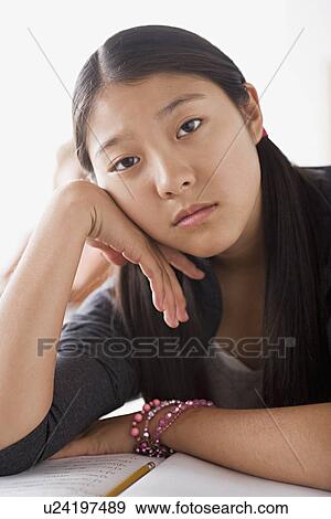 Stock Photo - Bored schoolgirl leaning on desk. Fotosearch