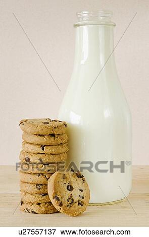 Stock Photo - Bottle of milk and chocolate chip cookies, studio shot. Fotosearch