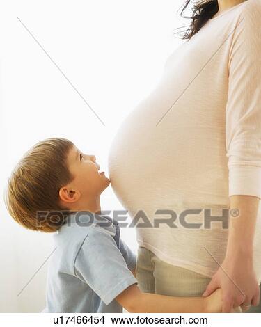 Boy (4-5) embracing pregnant mother View Large Photo Image Picture - Boy (4-5) embracing pregnant mother. Fotosearch