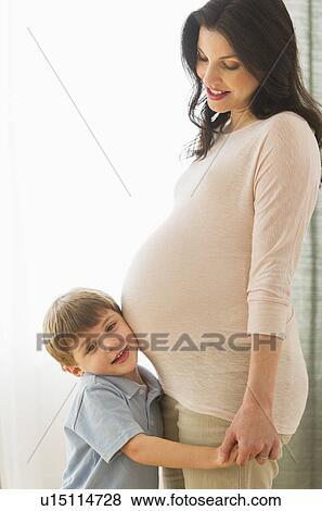 Boy (4-5) putting ear to pregnant mother's belly View Large Photo Image Stock Photo - Boy (4-5) putting ear to pregnant mother's belly. Fotosearch