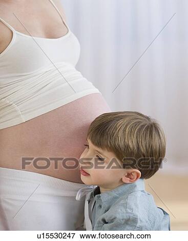 Boy (4-5) putting ear to pregnant mother's belly View Large Photo Image Stock Photo - Boy (4-5) putting ear to pregnant mother's belly. Fotosearch