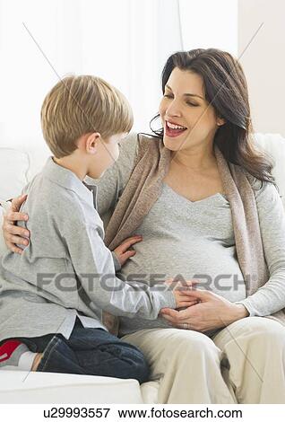 Boy (4-5) touching pregnant mother's belly View Large Photo Image Stock Photo - Boy (4-5) touching pregnant mother's belly. Fotosearch