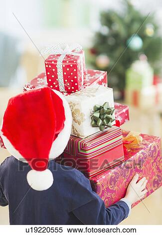 Boy (6-7) carrying christmas gifts View Large Photo Image Stock Photography - Boy (6-7) carrying christmas gifts. Fotosearch