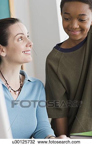 Stock Image - Boy and female teacher smiling. Fotosearch