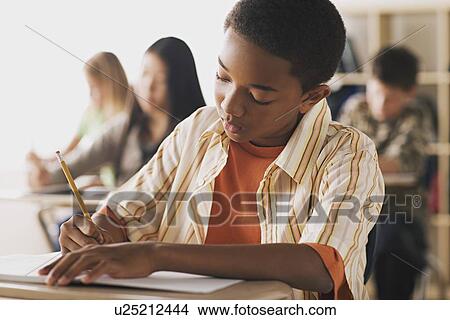 Boy doing notes in classroom View Large Photo Image Picture - Boy doing notes in classroom. Fotosearch