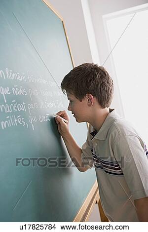 Boy writing on blackboard View Large Photo Image Picture - Boy writing on blackboard. Fotosearch