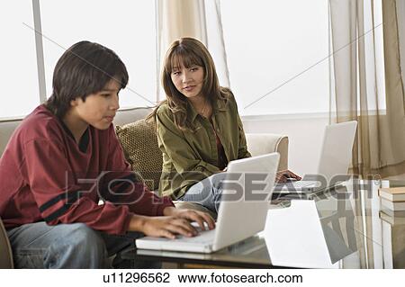 Brother and sister using laptops in living room View Large Photo Image Stock Image - Brother and sister using laptops in living room. Fotosearch