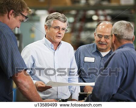 Businessman and workers talking in factory View Large Photo Image Stock Photo - Businessman and workers talking in factory. Fotosearch