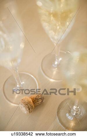 Champagne flutes and cork on table View Large Photo Image Stock Image - Champagne flutes and cork on table. Fotosearch