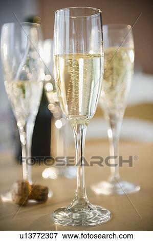 Champagne flutes and cork on table View Large Photo Image Stock Photo - Champagne flutes and cork on table. Fotosearch