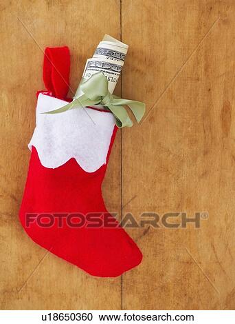 Stock Image - Christmas stocking with roll of banknotes. Fotosearch