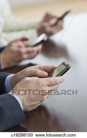 Stock Image - Close up of businessman's hands holding smartphone. Fotosearch