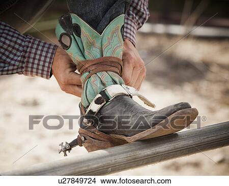 Close-up of cowboy tying shoe View Large Photo Image Picture - Close-up of cowboy tying shoe. Fotosearch