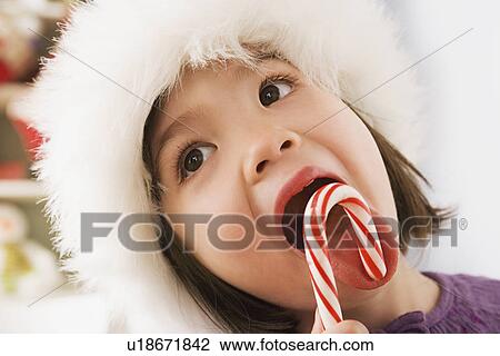 Close-up of girl (10-11) licking candycane View Large Photo Image Stock Image - Close-up of girl (10-11) licking candycane. Fotosearch