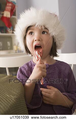 Stock Photo - Close-up of girl licking candy cane. Fotosearch