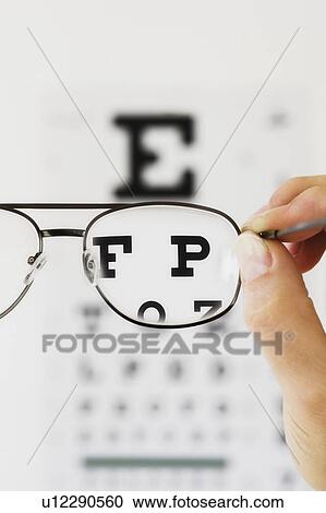 Close up of hand holding glasses above eye chart, studio shot View Large Photo Image Stock Image - Close up of hand holding glasses above eye chart, studio shot. Fotosearch