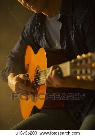 Close up of man playing acoustic guitar, studio shot View Large Photo Image Stock Image - Close up of man playing acoustic guitar, studio shot. Fotosearch