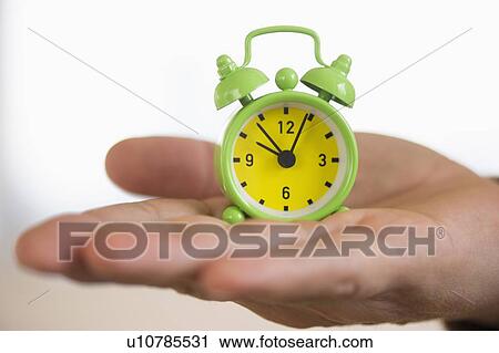 Close up of man's hand holding alarm clock, studio shot View Large Photo Image Stock Image - Close up of man's hand holding alarm clock, studio shot. Fotosearch