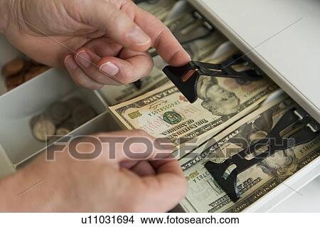 Close up of man's hand putting banknotes into cash register, studio shot View Large Photo Image Picture - Close up of man's hand putting banknotes into cash register, studio shot. Fotosearch