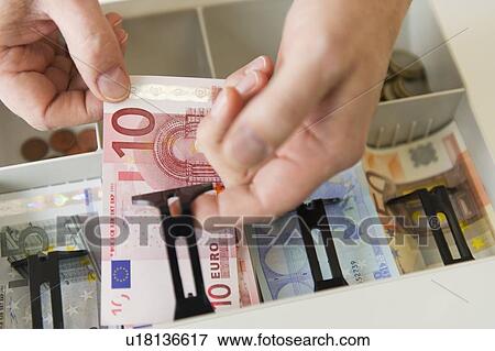 Close up of man's hand putting banknotes into cash register, studio shot View Large Photo Image Stock Photo - Close up of man's hand putting banknotes into cash register, studio shot. Fotosearch