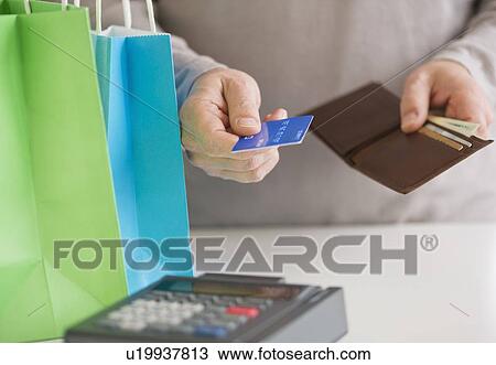 Close up of man's hands holding credit card and wallet, studio shot View Large Photo Image Stock Image - Close up of man's hands holding credit card and wallet, studio shot. Fotosearch