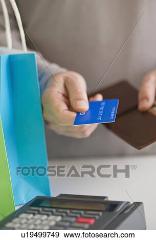 Close up of man's hands holding credit card and wallet, studio shot View Large Photo Image Stock Photo - Close up of man's hands holding credit card and wallet, studio shot. Fotosearch