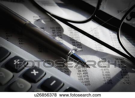 Stock Photo - Close up of pen, glasses and calculator, studio shot. Fotosearch