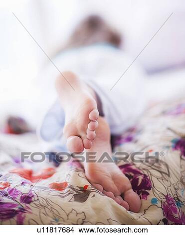 Close-up of woman's feet lying on bed View Large Photo Image Picture - Close-up of woman's feet lying on bed. Fotosearch